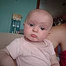 Nalah is registered to the contest to win money with this photo: baby, child, pout, face, arm, person, indoor, shirt, pink_clothing, skin, head, expression, holding, adult, box, wall, furniture, home, closeup, portrait