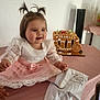 baby, child, girl, dress, lace, pigtails, table, pink, celebration, birthday, cake, gingerbread, carriage, decor, indoor, smiling, person, footwear, white_shoes, happy