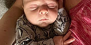 Alex is registered to the contest to win money with this photo: arm, baby, bed, casual, closeup, clothing, comfort, couch, face, hand, human, indoor, infant, peaceful, person, pink_shirt, resting, skin, sleeping, tender
