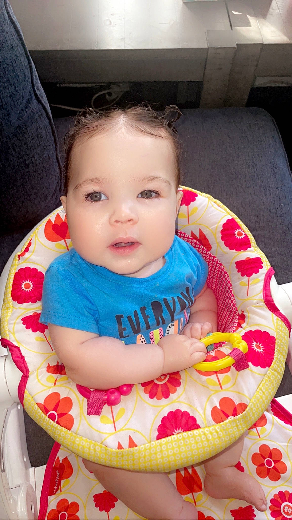 Zola is registered to the contest to win money with this photo: arm, baby, baby_products, baby_toddler_clothing, carmine, chair, cheek, child, comfort, dress, eye, face, fun, hand, happy, head, lap, pattern, person, sitting