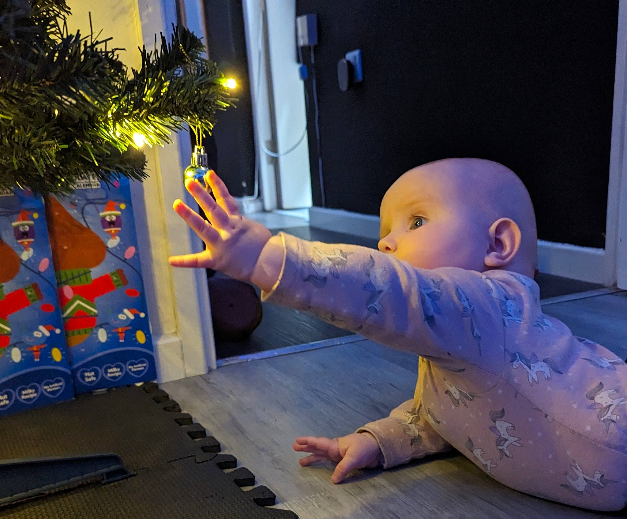 Aurora is registered to the contest to win money with this photo: baby, baby_toddler_clothing, child, electric_blue, fictional_character, finger, floor, flooring, fun, games, leisure, person, plant, play, purple, room, space, thumb, toddler, tree