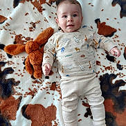 Abel a rejoint le concours — aidez-le/la à gagner de superbes lots ! animal_print, baby, blanket, bunny, child, clothing, cute, face, indoors, infant, lying_down, pants, pattern, portrait, smile, socks, soft_texture, stuffed_toy, toy, young_child