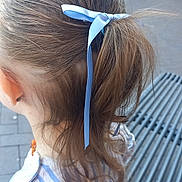Lyllloo participe au concours pour gagner de l'argent avec cette photo : back_view, blue_ribbon, brick_wall, building, candid, casual, child, curly_hair, daylight, ear, fashion, hair, metal_grate, necklace, outdoor, person, ponytail, side_view, striped_clothing, young_child