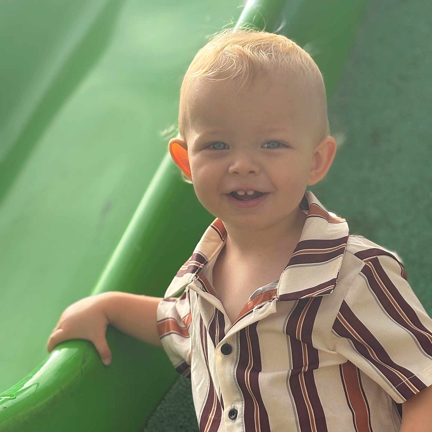 Ayden participe au concours pour gagner de l'argent avec cette photo : blond_hair, blue_eyes, casual_clothing, child, cute, daylight, fun, green_slide, hand, happy, kid, outdoor, play, playground, portrait, short_sleeves, smiling, striped_shirt, toddler, young_child