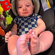 Elijah is registered to the contest to win money with this photo: baby, car_seat, checkered_pattern, child, closeup, colorful, comfort, cute, expression, face, feet, hands, indoor, infant, onesie, playful, portrait, seat_belt, toys, warning_label