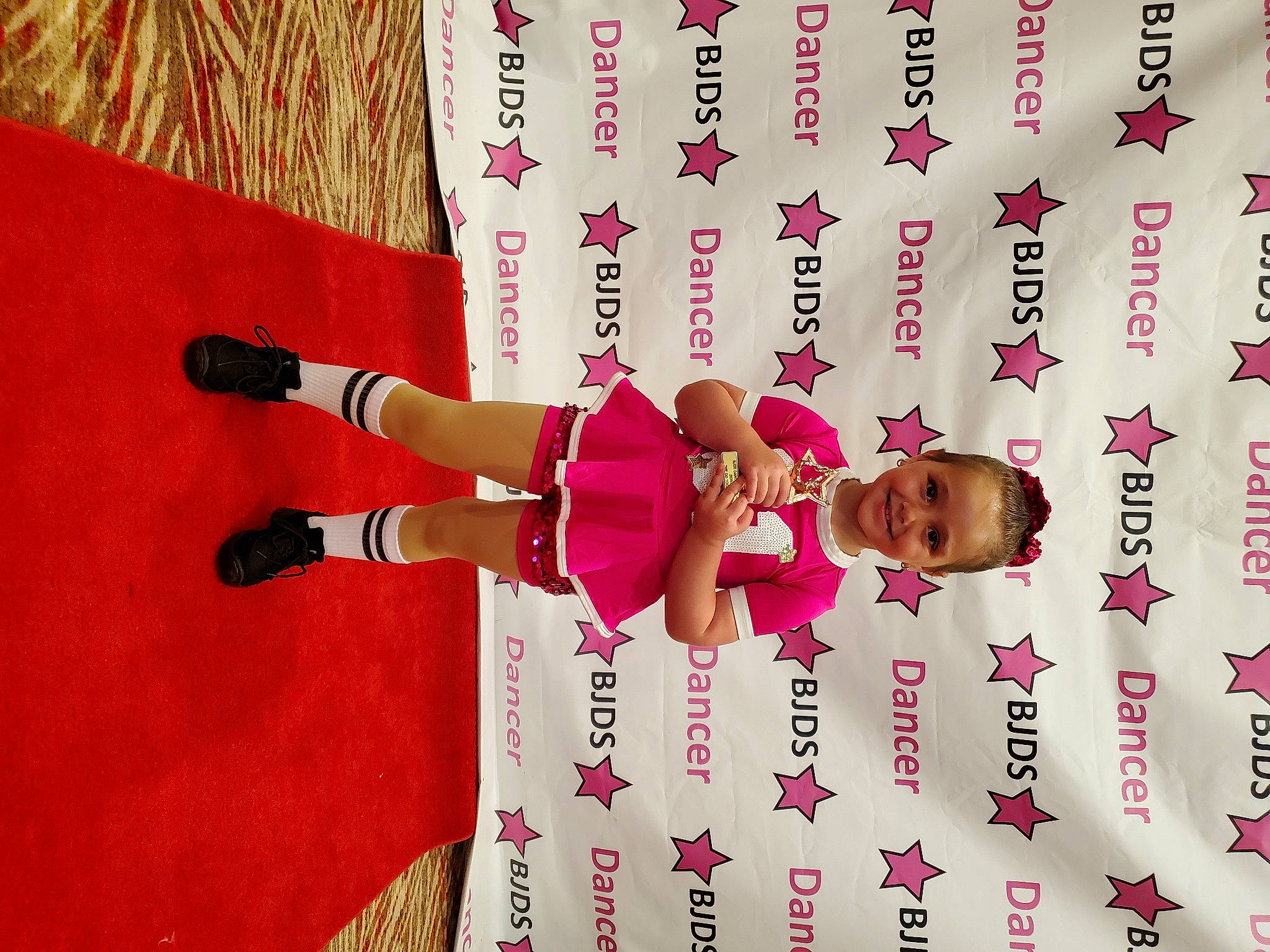 Victoria joined the competition — help win amazing prizes! carmine, child, elbow, finger, font, fun, graphic_design, happy, human_body, human_leg, joy, knee, line, magenta, person, pink, red, shorts, thigh, thumb