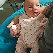 Théa participe au concours pour gagner de l'argent avec cette photo : baby, newborn, infant, person, face, hand, clothing, onesie, floral_pattern, cushion, blue, soft_lighting, cradled, adult, portrait, indoors, resting, cute, cozy, sleepy