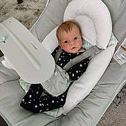 Donald joined the competition — help win amazing prizes! baby, infant, baby_seat, onesie, stars_pattern, face, eyes, head_support, straps, cushion, carpet, floor, indoors, baby_gear, baby_bouncer, child, person, cute, comfort, resting