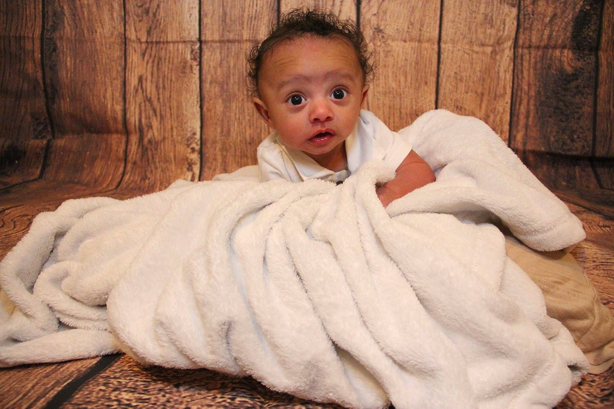 Jaydan is registered to the contest to win money with this photo: baby, blanket, child, fur, fur_clothing, linens, outerwear, person, robe, skin, surprise, textile, toddler, wool