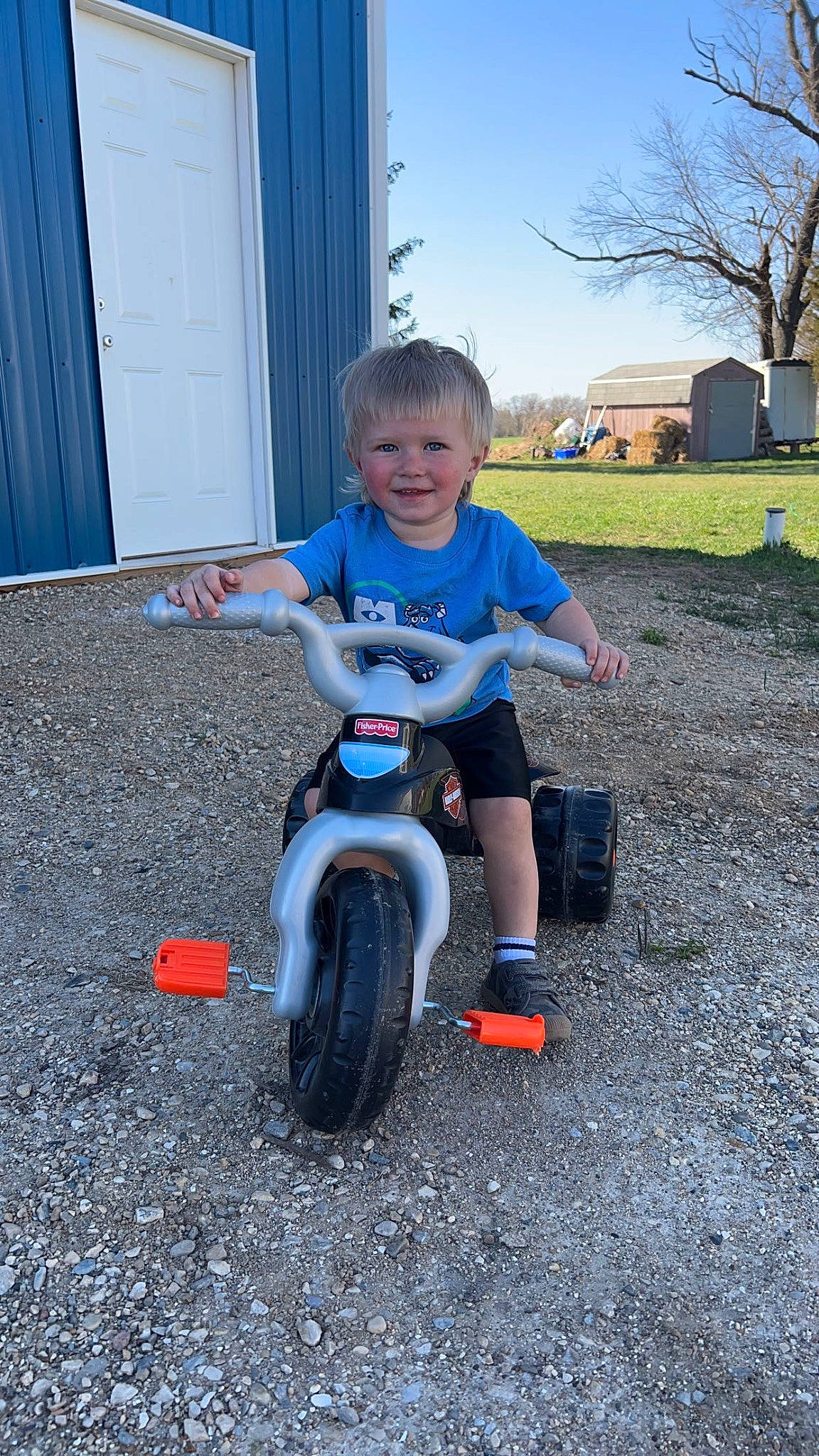 Brooks is registered to the contest to win money with this photo: automotive_tire, automotive_wheel_system, bicycle, bicycle_accessory, fender, grass, joy, person, plant, recreation, riding_toy, rim, rolling, sky, smile, spoke, tire, toddler, tread, tree