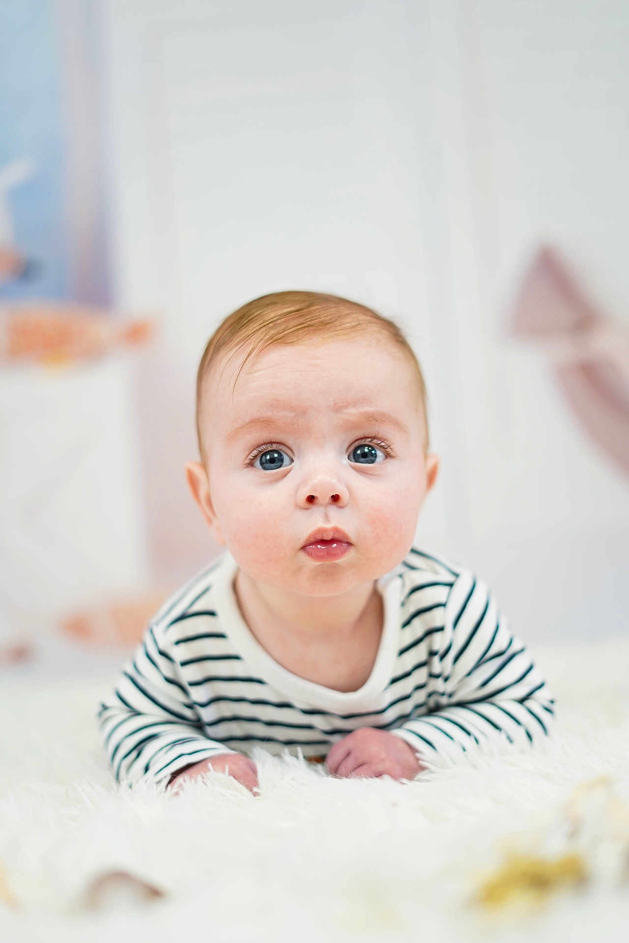 Sacha a rejoint le concours — aidez-le/la à gagner de superbes lots ! baby, child, closeup, curious, cute, expression, eyes, face, fluffy_surface, hands, head, indoor, infant, lying_down, person, portrait, skin, soft_background, striped_shirt, young