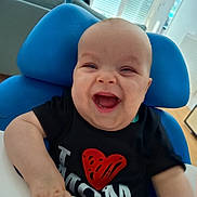 Maxence participe au concours pour gagner de l'argent avec cette photo : baby, black_shirt, blue_pillow, child, cute, furniture, hand, happy, high_chair, home, indoor, infant, light, person, portrait, red_heart, room, smiling, window, young_child