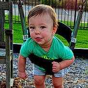 Harper is registered to the contest to win money with this photo: toddler, child, playground, swing, outdoor, sunset, sun_flare, smiling, portrait, green_shirt, shorts, barefoot, wood_chips, backyard, fence, basketball_hoop, grass, playground_equipment, sitting, happy