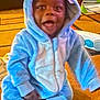 Zymir joined the competition — help win amazing prizes! toddler, child, blue_onesie, costume, indoor, carpet, smiling, happy, baby, sitting, toy, furniture, sock, hood, cute, playful, cozy, home, young_child, infant