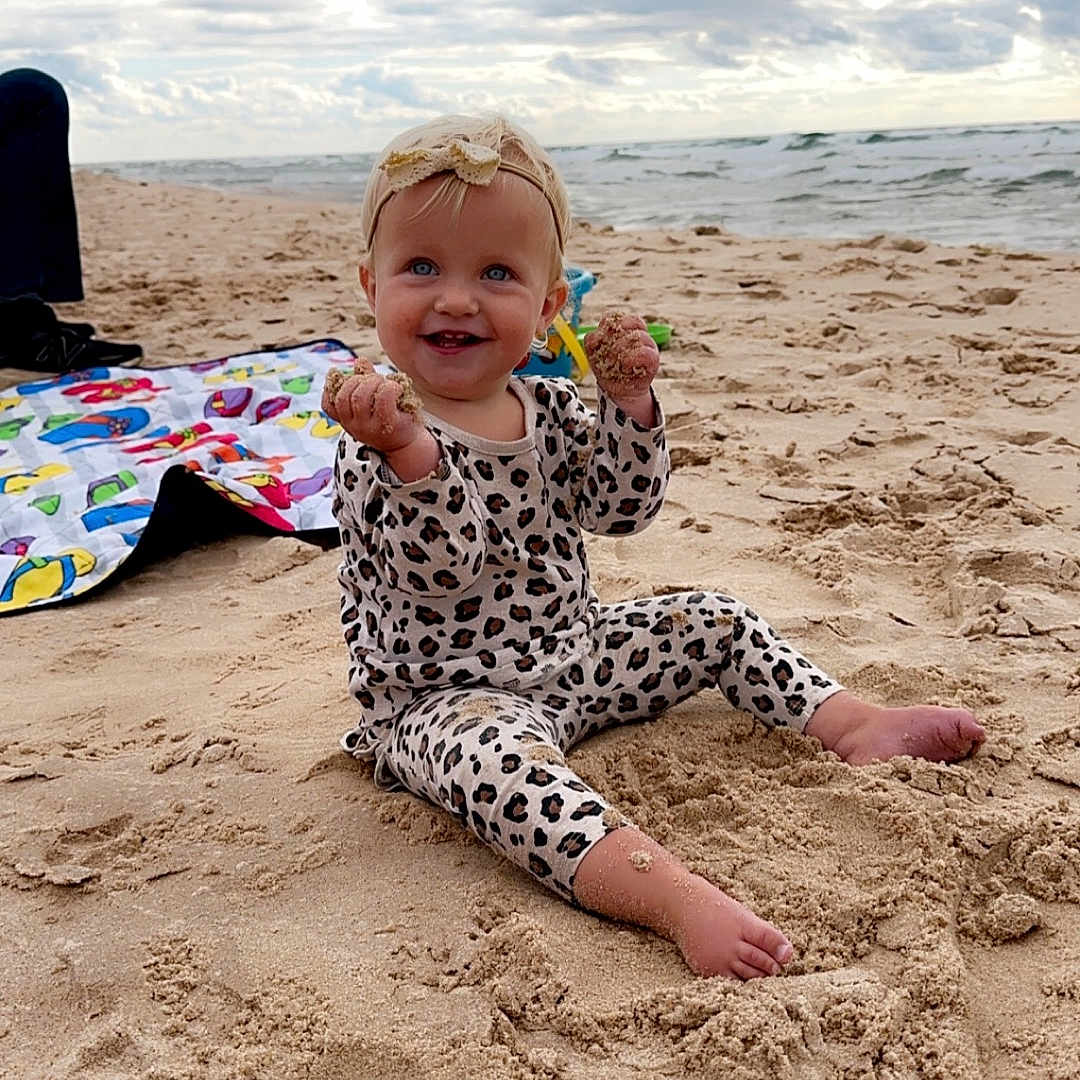 Elizabeth Janet is registered to the contest to win money with this photo: baby, beach, beachwear, bodypart, clothing, coast, face, finger, hand, head, nature, outdoors, person, photography, portrait, sea, shoreline, soil, summer, water