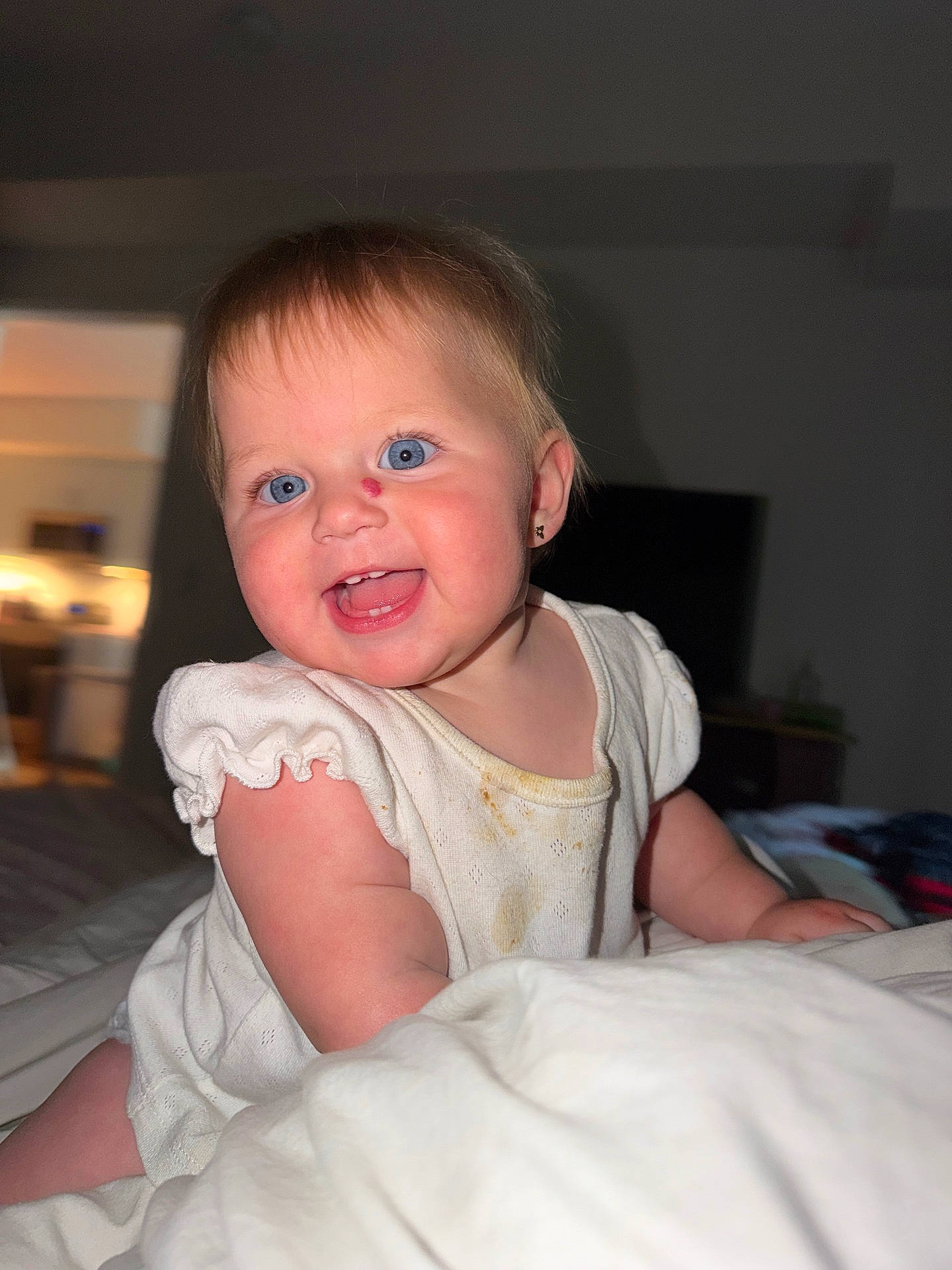 Sarah is registered to the contest to win money with this photo: baby, bedroom, blanket, blue_eyes, child, crawling, cute, earring, expression, face, happy, indoor, infant, person, portrait, skin, smiling, stain, white_clothing, young