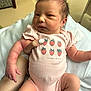 Clementine joined the competition — help win amazing prizes! newborn, baby, infant, pink_onesie, strawberries, baby_clothing, human_hand, manicured_nails, hospital_bracelet, blanket, indoor, person, face, skin, cute, resting, holding, baby_legs, baby_arms, expression