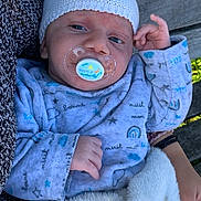 Mylan participe au concours pour gagner de l'argent avec cette photo : baby, pacifier, knit_hat, blanket, onesie, infant, outdoor, bench, hand, person, cute, resting, soft, clothing, child, comfort, sleepy, warm, closeup, portrait