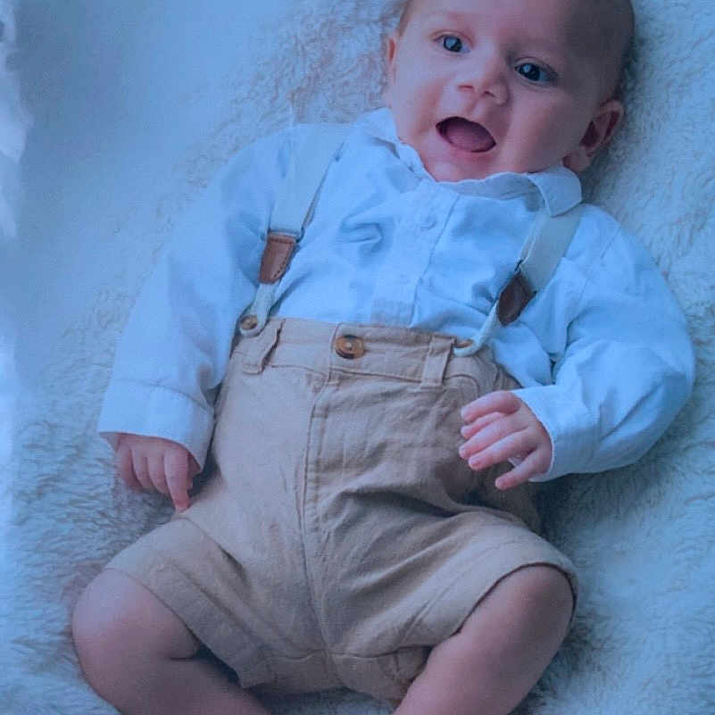 Mylan participe au concours pour gagner de l'argent avec cette photo : baby, barefoot, beige_shorts, blanket, child, cute, face, happy, head, indoors, infant, legs, portrait, relaxed, skin, small_hands, smiling, soft_texture, suspenders, white_shirt