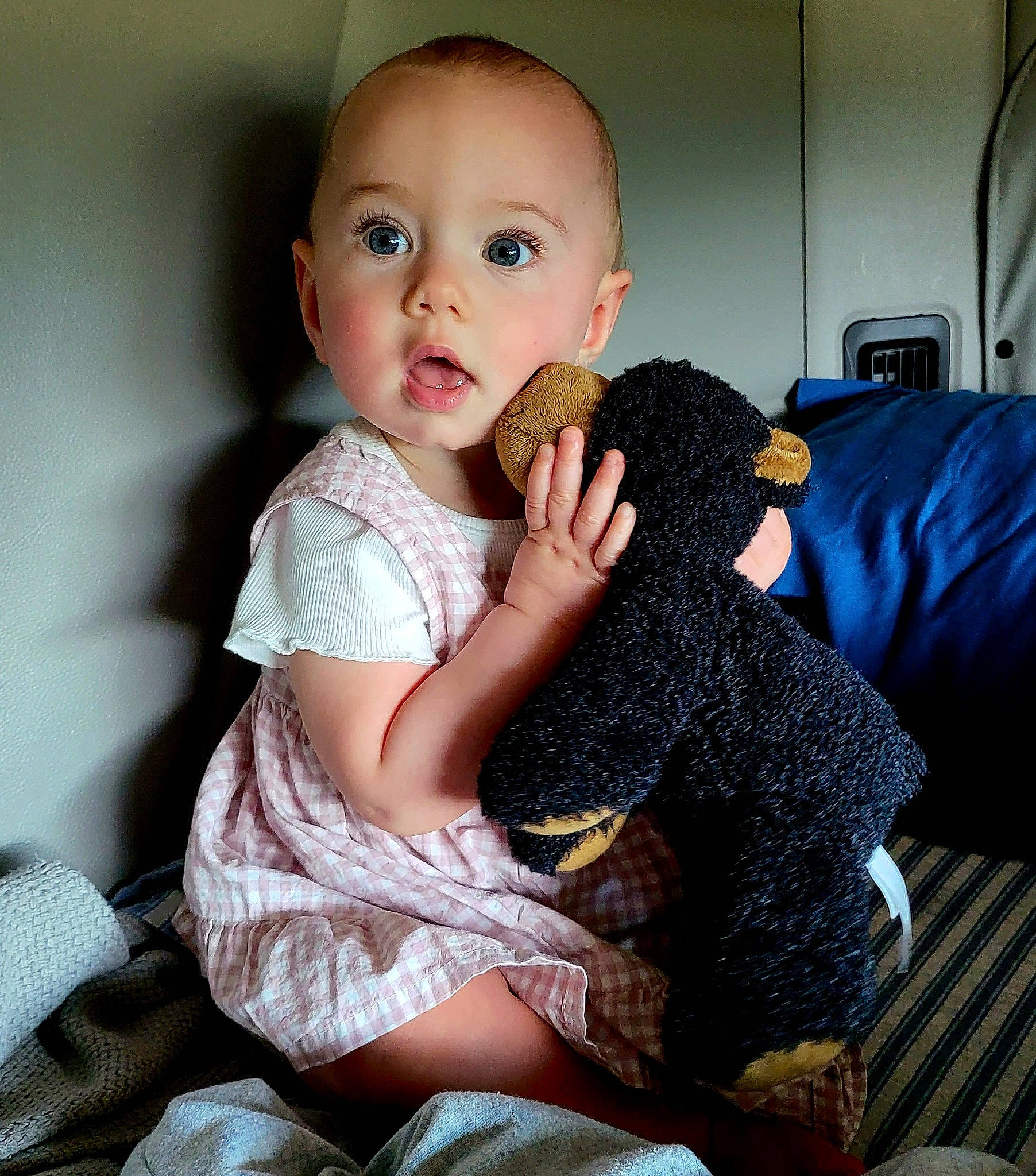 Aiyana is registered to the contest to win money with this photo: baby_toddler_clothing, child, comfort, couch, doll, eyelash, finger, fur, happy, human_body, human_leg, iris, lap, nail, pattern, person, sitting, skin, surprise, thigh