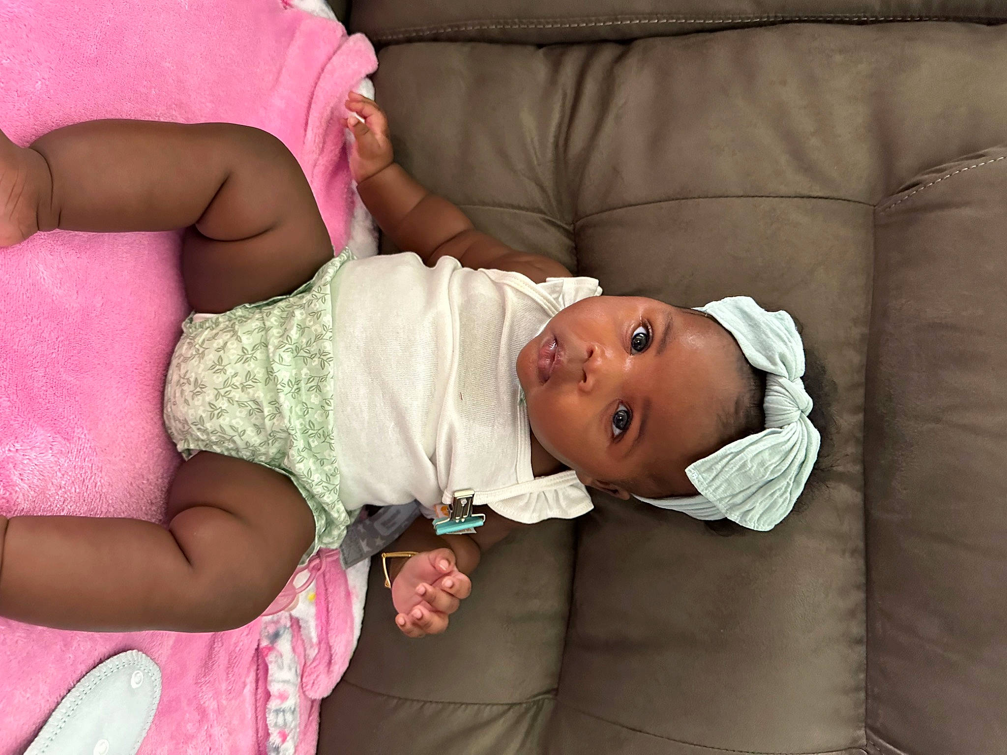 Cali is registered to the contest to win money with this photo: arm, baby, baby_toddler_clothing, cheek, child, comfort, eye, finger, gesture, glasses, hand, head, headwear, human_body, joint, pattern, person, pink, skin, sleeve