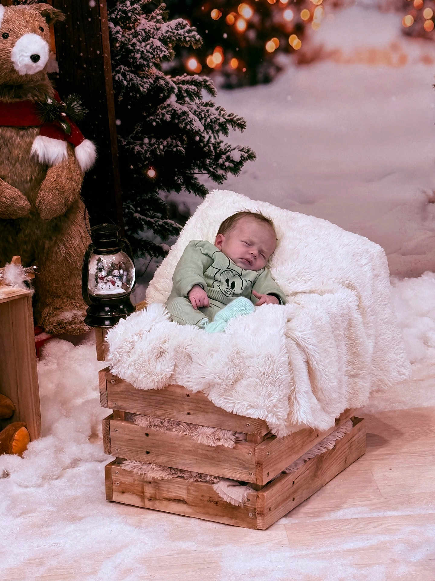 Timéo a rejoint le concours — aidez-le/la à gagner de superbes lots ! baby, infant, sleeping_baby, blanket, wooden_crate, stuffed_bear, lantern, snow, christmas_tree, holiday_decor, cozy, fur_throw, bokeh_lights, portrait, soft_texture, wood_floor, decorative_scene, cute, nursery_style, seasonal