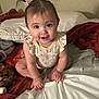 baby, child, pigtails, pink_hair_clips, bed, blankets, pillow, smile, happy, cute, indoor, person, young_child, sitting, hand, face, skin, clothing, infant, curious