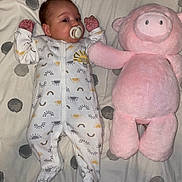 Renesmee joined the competition — help win amazing prizes! baby, pacifier, plush_toy, pink, bedspread, sleepwear, infant, polka_dot, stuffed_animal, cute, child, lying_down, soft_toy, comfort, smiling, nap_time, indoors, sleep_suit, toy, resting