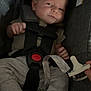 baby, infant, car_seat, safety_harness, pacifier, hand, clothing, foot, grey_pants, indoor, child, seat_belt, resting, cute, newborn, person, comfort, straps, fabric, closeup