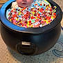 baby, cauldron, candy, carpet, indoor, child, colorful, playful, cute, fantasy, halloween, graphics, patterned, black, toy, floor, infant, wrapped, blanket, decor