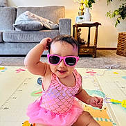 Azlin Mehrish is registered to the contest to win money with this photo: baby, child, pink_sunglasses, pink_tutu, play_mat, living_room, couch, table, lamp, plants, smiling, sitting, cute, indoors, toddler, fun, happy, toy, colorful, decor