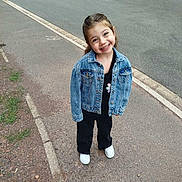 Juditte a rejoint le concours — aidez-le/la à gagner de superbes lots ! black_pants, car, casual_clothing, child, curly_hair, daylight, denim_jacket, girl, happy, nature, outdoor, pavement, person, posing, road, sidewalk, smiling, street, urban, white_shoes