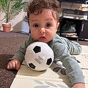 Dany joined the competition — help win amazing prizes! baby, cabinet, carpet, child, clothing, crawling, curious, curly_hair, face, floor, hand, home, indoor, living_room, person, play_mat, potted_plant, soccer_ball, television, toy