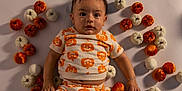 Alessandro joined the competition — help win amazing prizes! baby, child, pumpkin, orange, white, patterned_clothing, bracelet, lying_down, cute, holiday, halloween, autumn, decor, small_pumpkins, infant, portrait, indoors, skin, face, hand