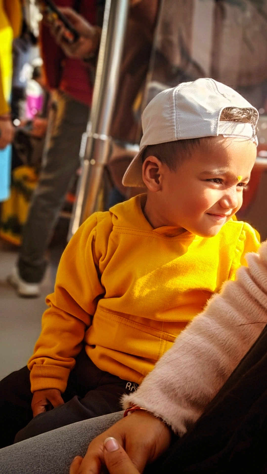 Ansh joined the competition — help win amazing prizes! child, boy, yellow_hoodie, white_cap, smiling, portrait, indoor, casual_clothing, sunlight, warm_light, person, seated, happy, close_up, fashion, young, people, blurry_background, hand, candid