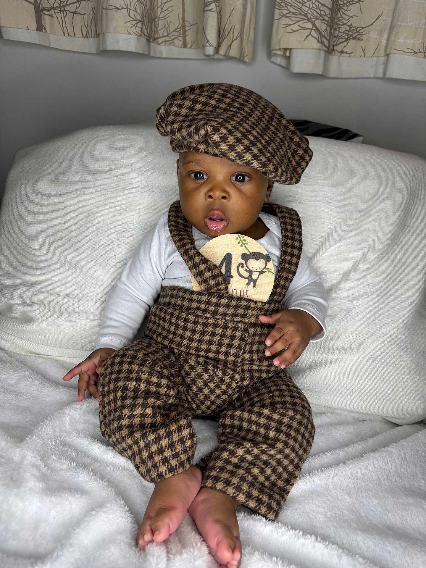 Joel joined the competition — help win amazing prizes! baby, child, infant, fashion, hat, checkered_pattern, brown, white_blanket, curious, sitting, indoors, portrait, cute, feet, hand, clothing, face, expression, soft_texture, couch
