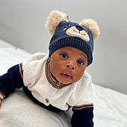 Joel joined the competition — help win amazing prizes! baby, child, hat, bear_ears, sweater, knitwear, cute, infant, portrait, indoor, soft_lighting, expression, cozy, warm_clothing, person, face, wide_eyes, curious, lying_down, white_background