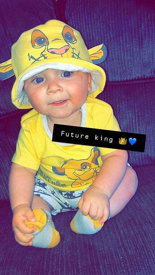 Amarion joined the competition — help win amazing prizes! baby, cap, child, fashion_accessory, finger, fun, hat, headgear, headwear, person, smile, thumb, toddler, yellow