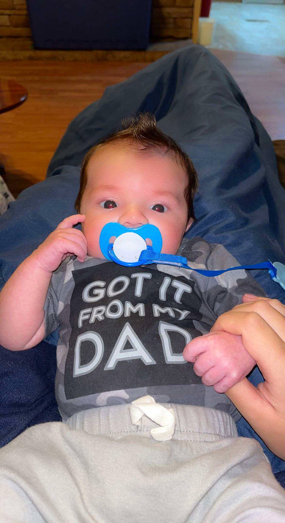 Parker is registered to the contest to win money with this photo: azure, baby, baby_toddler_clothing, cheek, comfort, cool, electric_blue, facial_expression, finger, fun, hairstyle, happy, iris, mouth, nail, person, sitting, sleeve, t_shirt, toddler