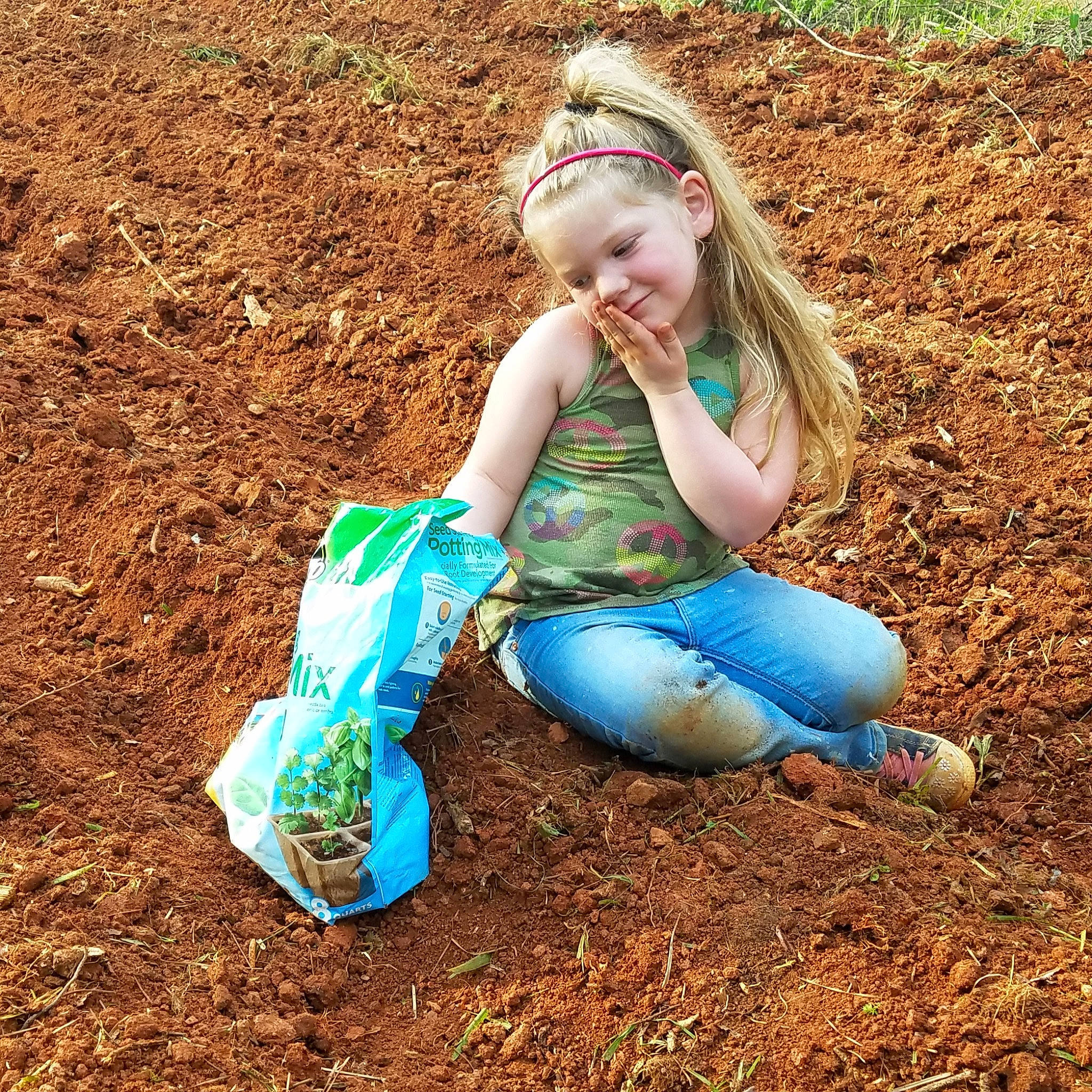 Katarina is registered to the contest to win money with this photo: blond, child, grass, joy, mud, people_in_nature, person, plant, sitting, soil
