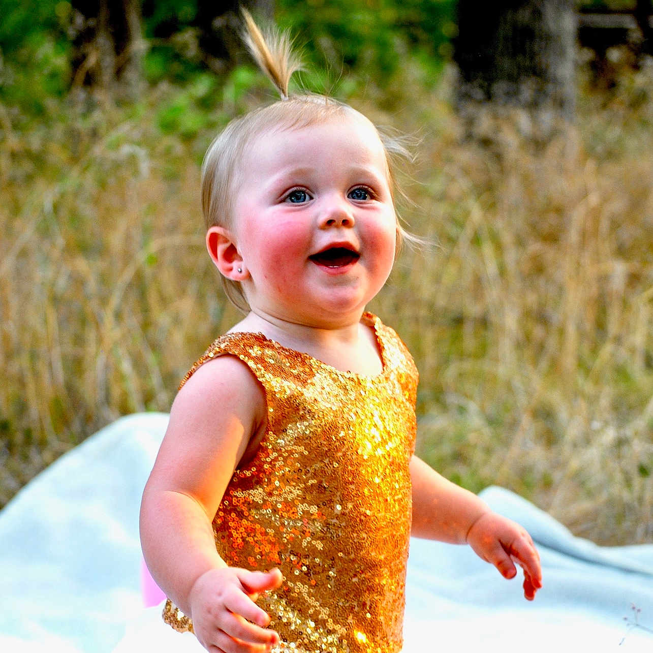 Charlee is registered to the contest to win money with this photo: baby, bodypart, clothing, dress, face, fashion, finger, formalwear, gown, grass, hand, happy, head, laughing, outdoors, person, photography, plant, portrait, smile
