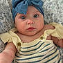 Lainey joined the competition — help win amazing prizes! baby, infant, blue_eyes, headband, bow, striped_clothing, knitted, blanket, floral_pattern, close_up, portrait, cute, child, person, young, indoor, soft_light, apparel, button, curious