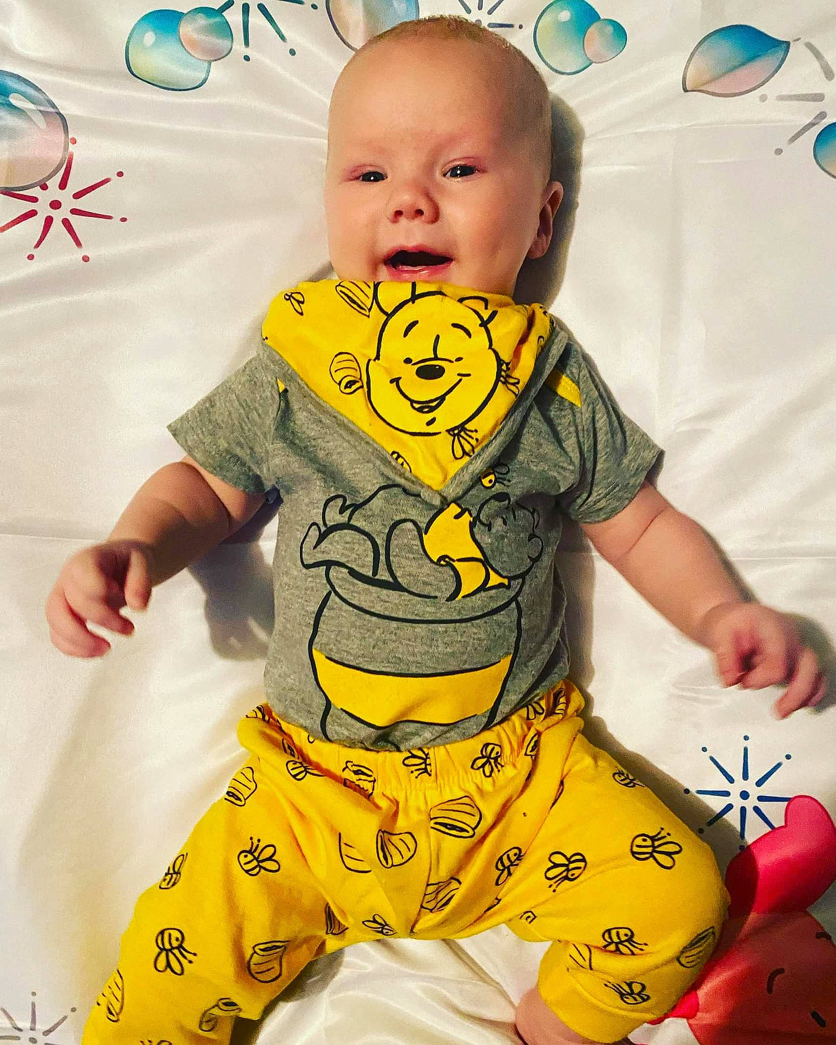 Apollo is registered to the contest to win money with this photo: art, baby, baby_toddler_clothing, cheek, child, face, facial_expression, font, green, happy, head, pattern, person, photograph, sitting, sleeve, sportswear, t_shirt, toddler, white