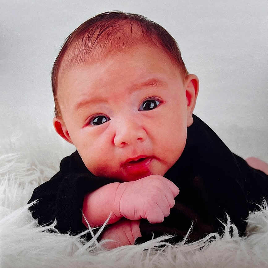 Manahiva participe au concours pour gagner de l'argent avec cette photo : baby, black_clothing, child, closeup, cute, expression, eyes, face, fluffy_surface, hand, head, indoors, infant, lying_down, newborn, person, portrait, skin, soft_texture, young_child