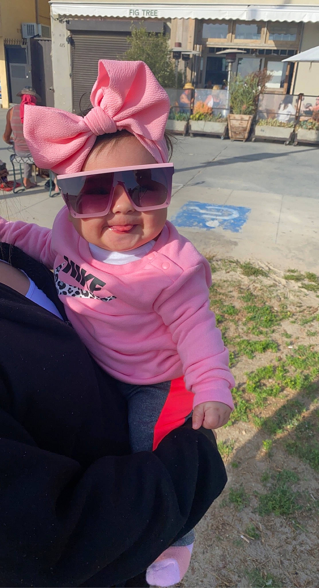 Enalise is registered to the contest to win money with this photo: asphalt, baseball_cap, cap, eyewear, glasses, goggles, grass, happy, hat, headgear, leisure, magenta, person, pink, plant, purple, sun_hat, sunglasses, toddler, tree
