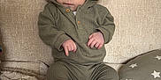 Onnie-Clay is registered to the contest to win money with this photo: baby, blanket, casual, child, couch, cozy, expression, fabric, face, feet, green_clothing, hands, home, hoodie, indoor, infant, pillow, portrait, sitting, soft_texture