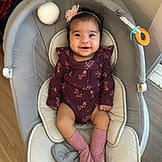 Harnoor joined the competition — help win amazing prizes! baby, infant, smiling_baby, onesie, headband, pink_socks, baby_seat, bouncer, toy_ring, soft_ball, chubby_cheeks, dark_hair, indoor, wood_floor, cozy, portrait, happy, hands, legs, cute