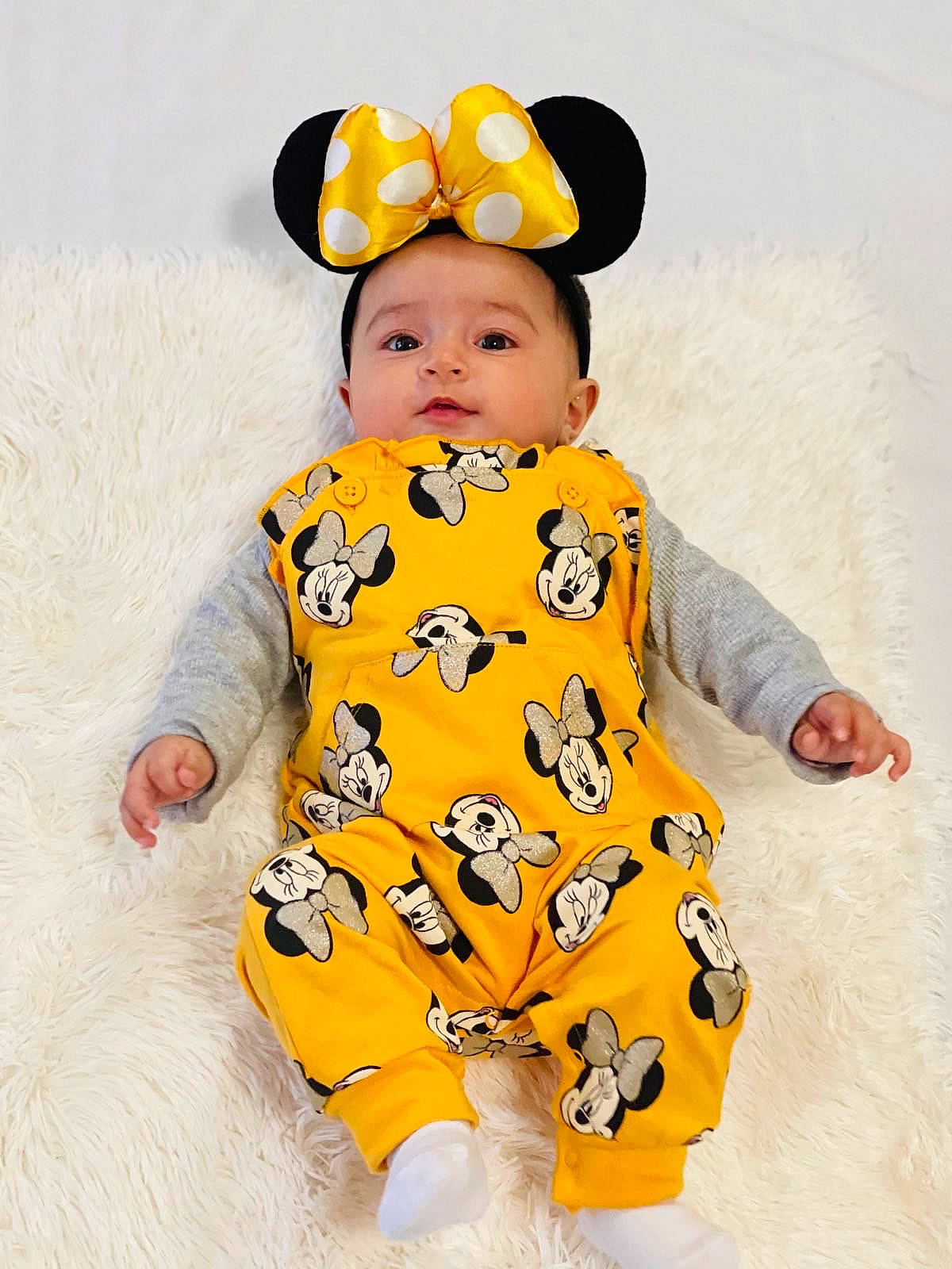 Miral is registered to the contest to win money with this photo: baby, baby_products, baby_toddler_clothing, child, collar, costume_accessory, costume_hat, dress, happy, hat, headgear, pattern, person, photograph, sitting, sleeve, t_shirt, toddler, white