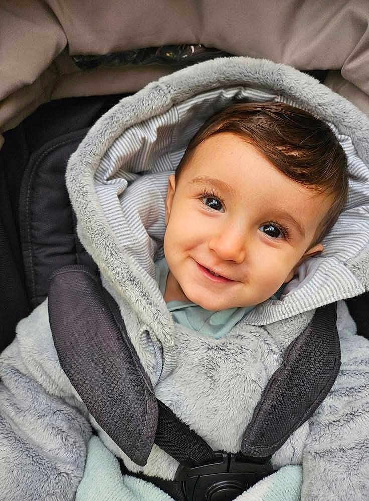 Elijah-Jabran is registered to the contest to win money with this photo: baby, child, smile, face, hood, fur, car_seat, straps, clothing, infant, cute, warm, cozy, closeup, portrait, young_child, eyes, head, outerwear, baby_boy