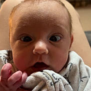 Hazel joined the competition — help win amazing prizes! baby, infant, close_up, face, blanket, hand, curious, expression, indoors, cozy, soft_lighting, portrait, child, newborn, wrapped, cute, person, skin, young, head